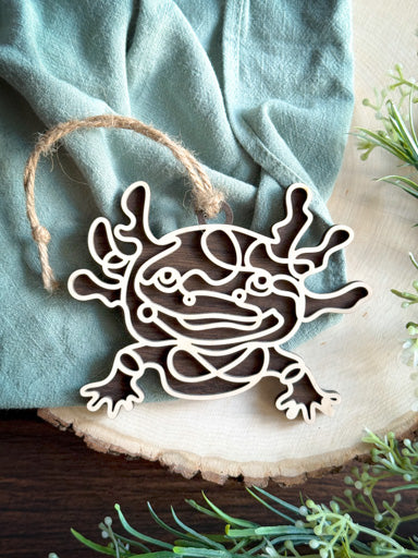 Axolotl line art ornament laser cut from natural wood in continuous line style