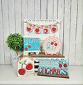 Decorative signs with cherry designs on a white surface and wooden background