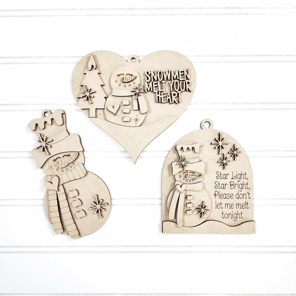 Set of wooden Christmas ornaments with snowmen and text on a white background