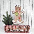 Decorative gingerbread man with 'GINGERBREAD cookies' text on a wooden background