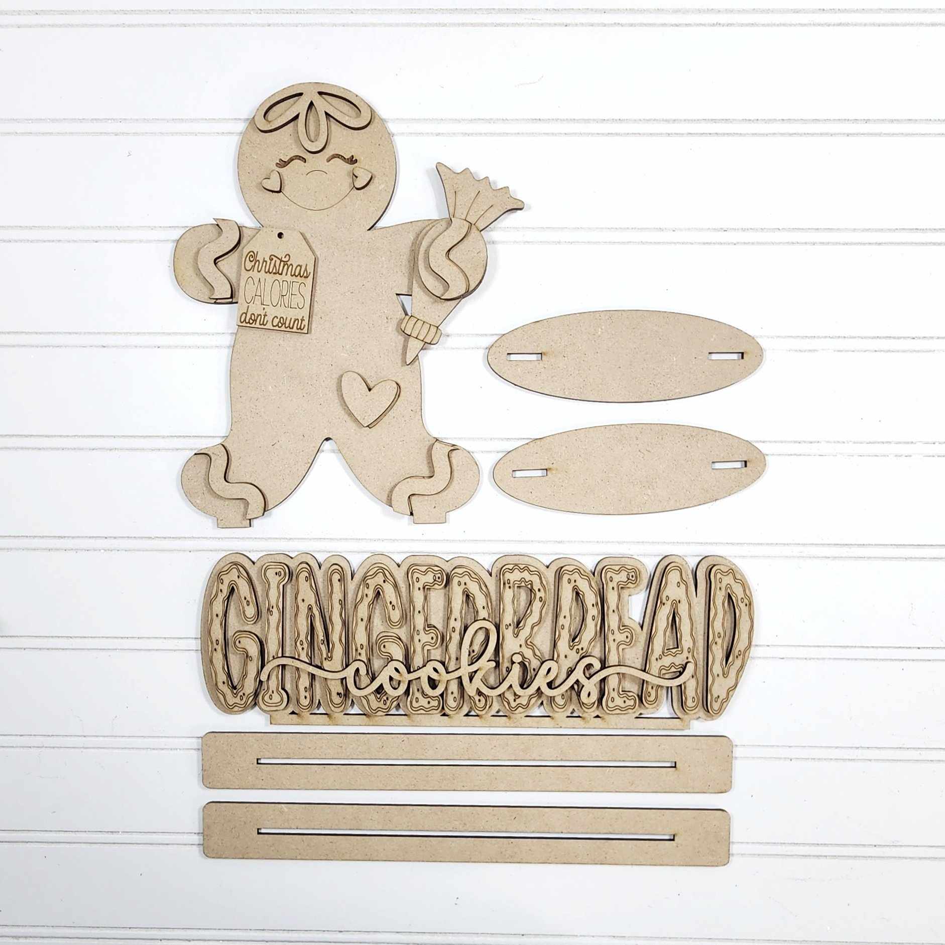 Wooden gingerbread man decoration with 'GINGERDEAD cookies' text on a white background