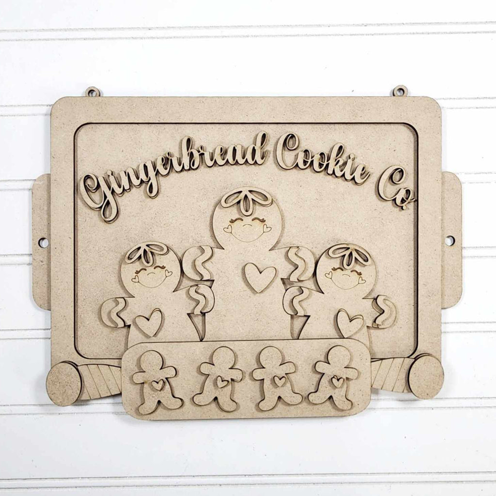 Wooden cookie cutter set with gingerbread people design on a white background