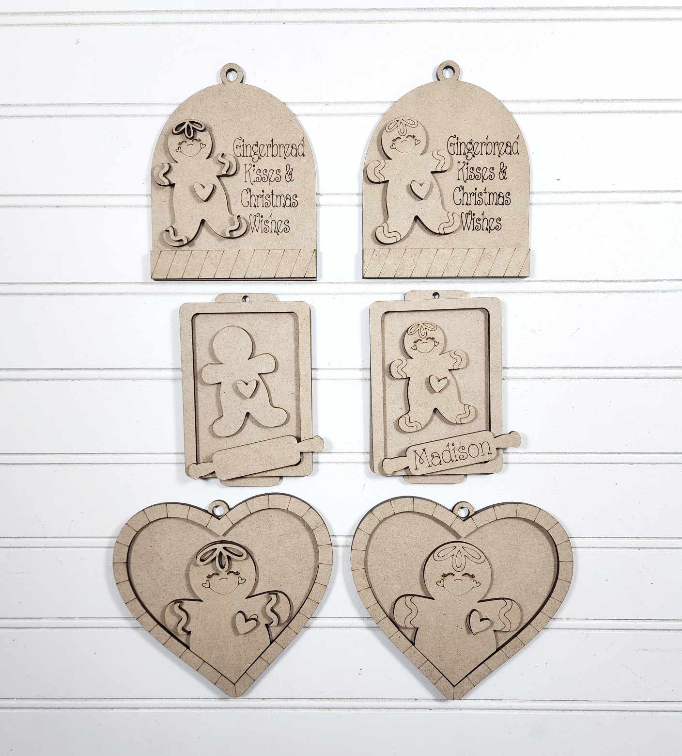 Set of wooden ornaments with gingerbread man designs on a white background