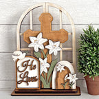 Wooden cross with lilies and 'He Lives' sign on a wooden background