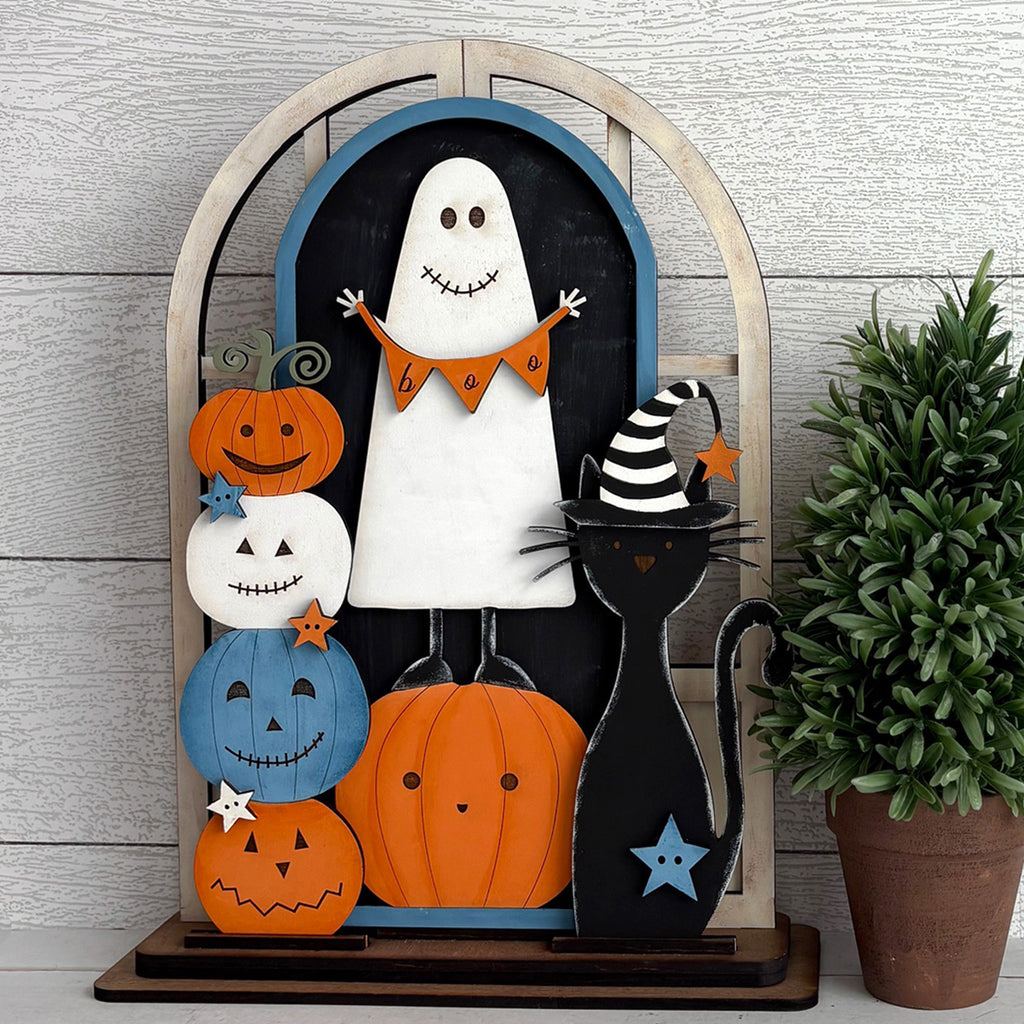 Halloween-themed decorative display with pumpkins, a ghost, and a black cat on a wooden arch.
