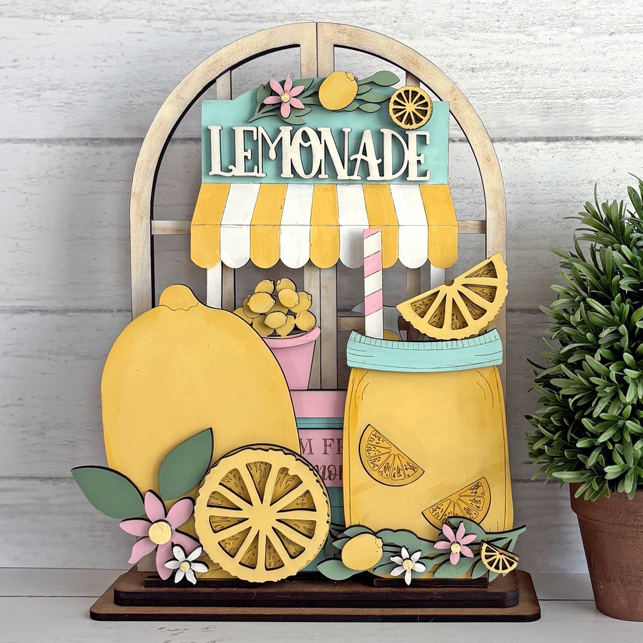Decorative sign with lemonade stand design on a wooden background