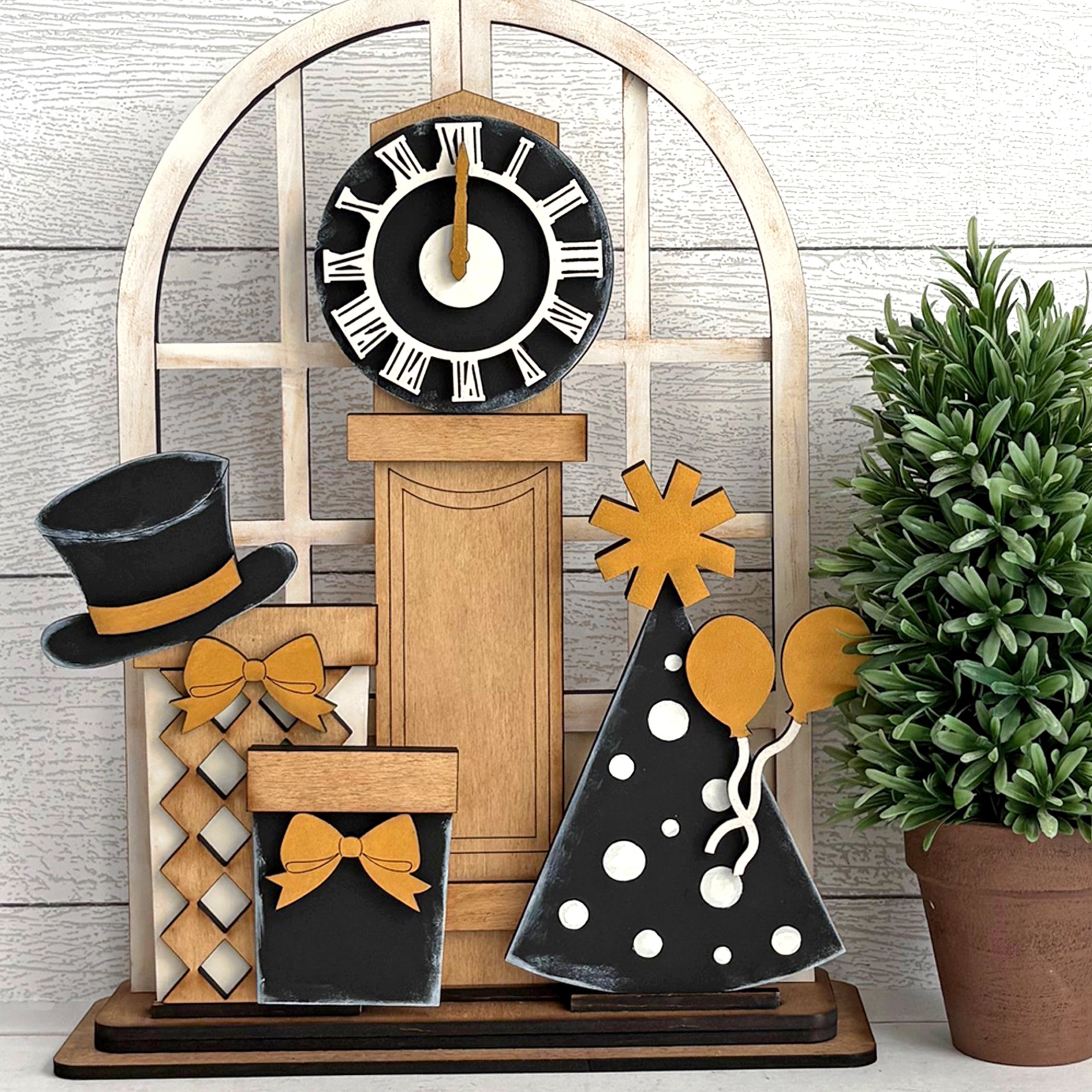Decorative items including a clock, top hat, and decorative trees on a wooden stand celebrating the new year.