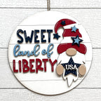 Decorative sign with 'Sweet Land of Liberty' text and a gnome design on a white background.
