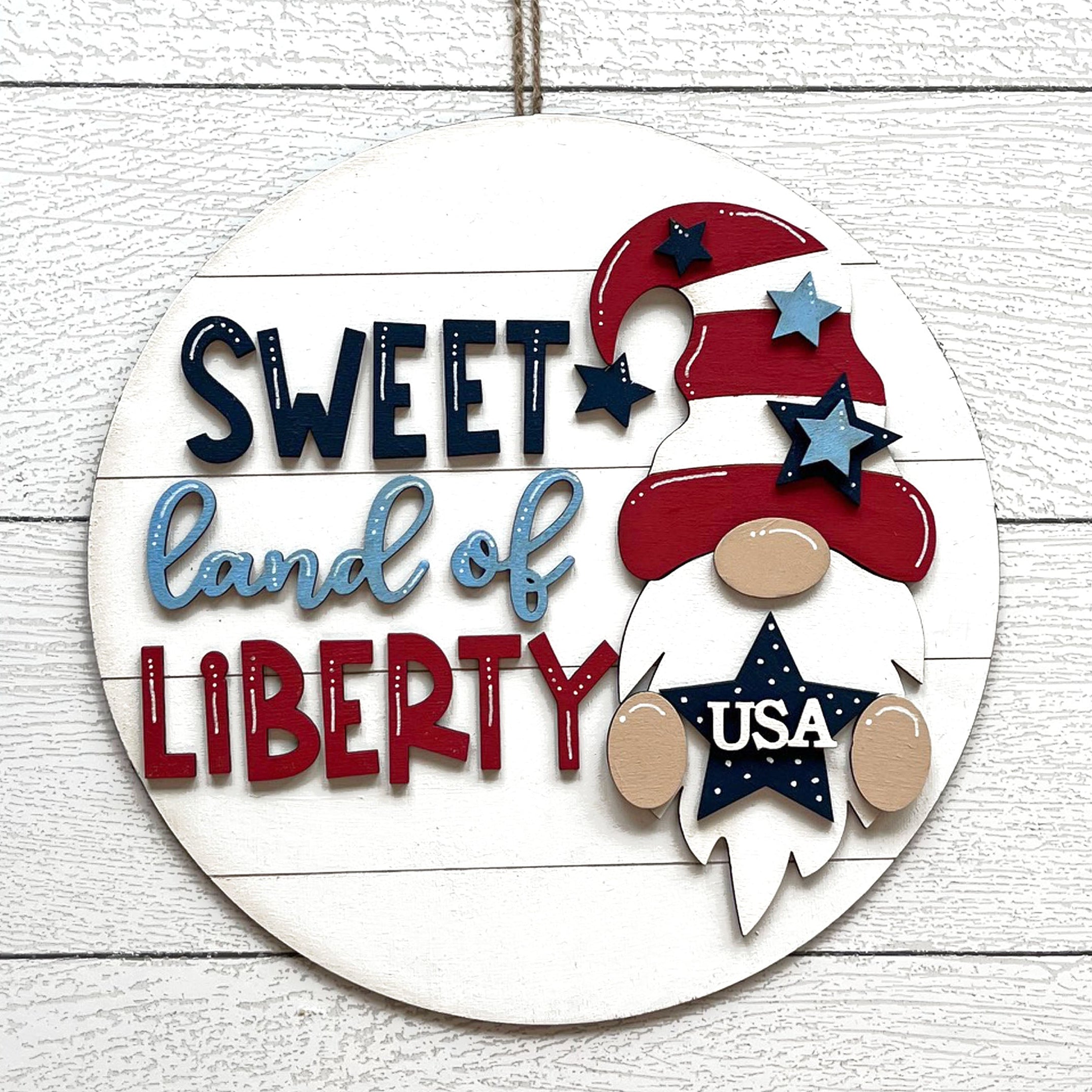Decorative sign with 'Sweet Land of Liberty' text and a gnome design on a white background.