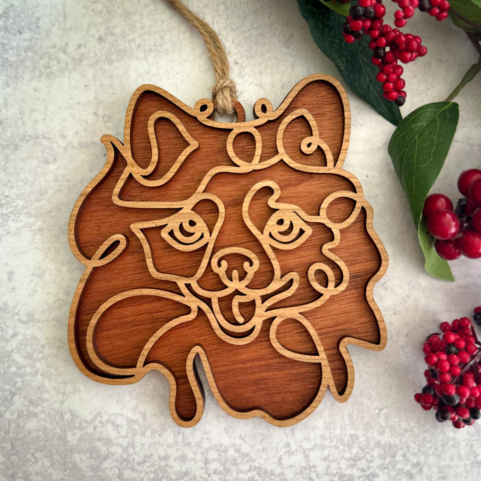 Pomeranian line art dog ornament laser cut from natural wood.