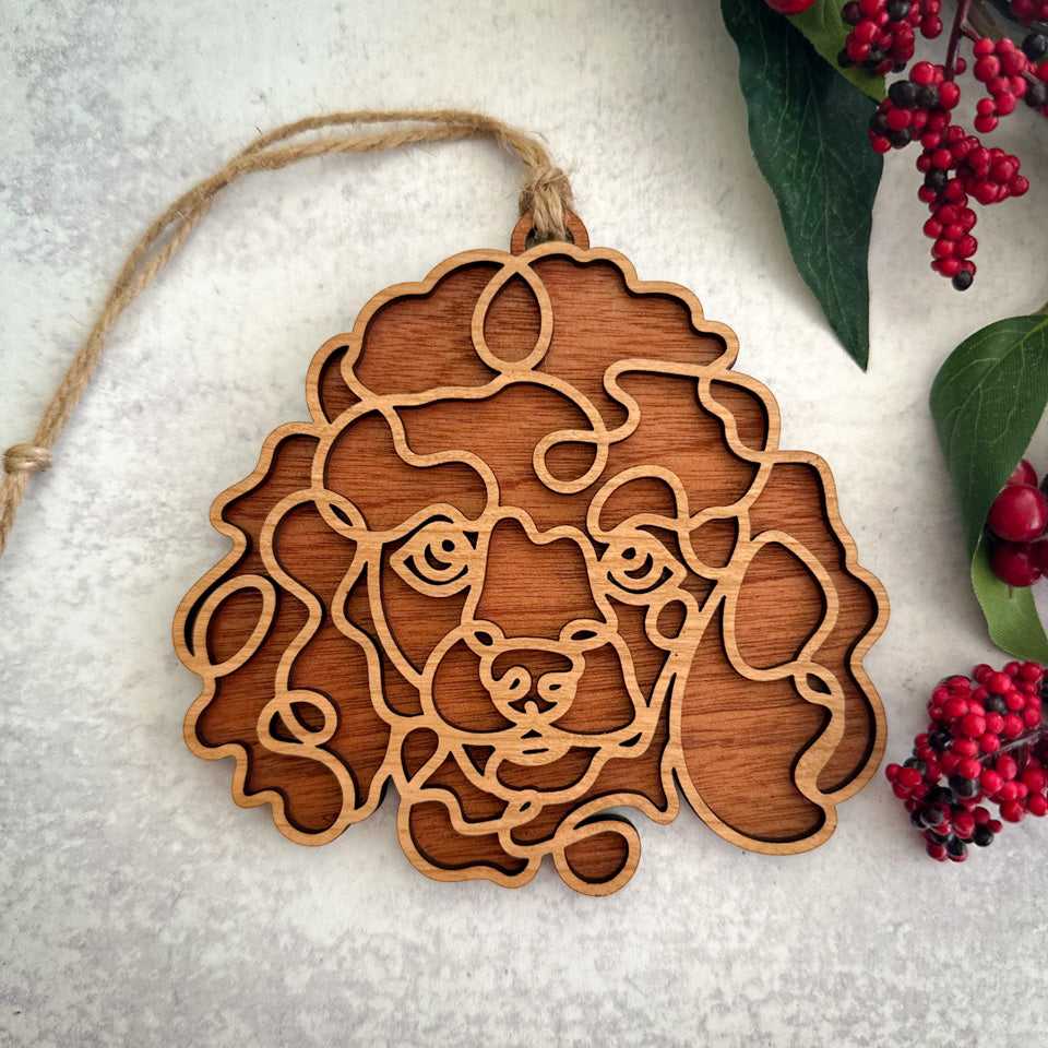 Poodle line art dog ornament laser cut from natural wood.