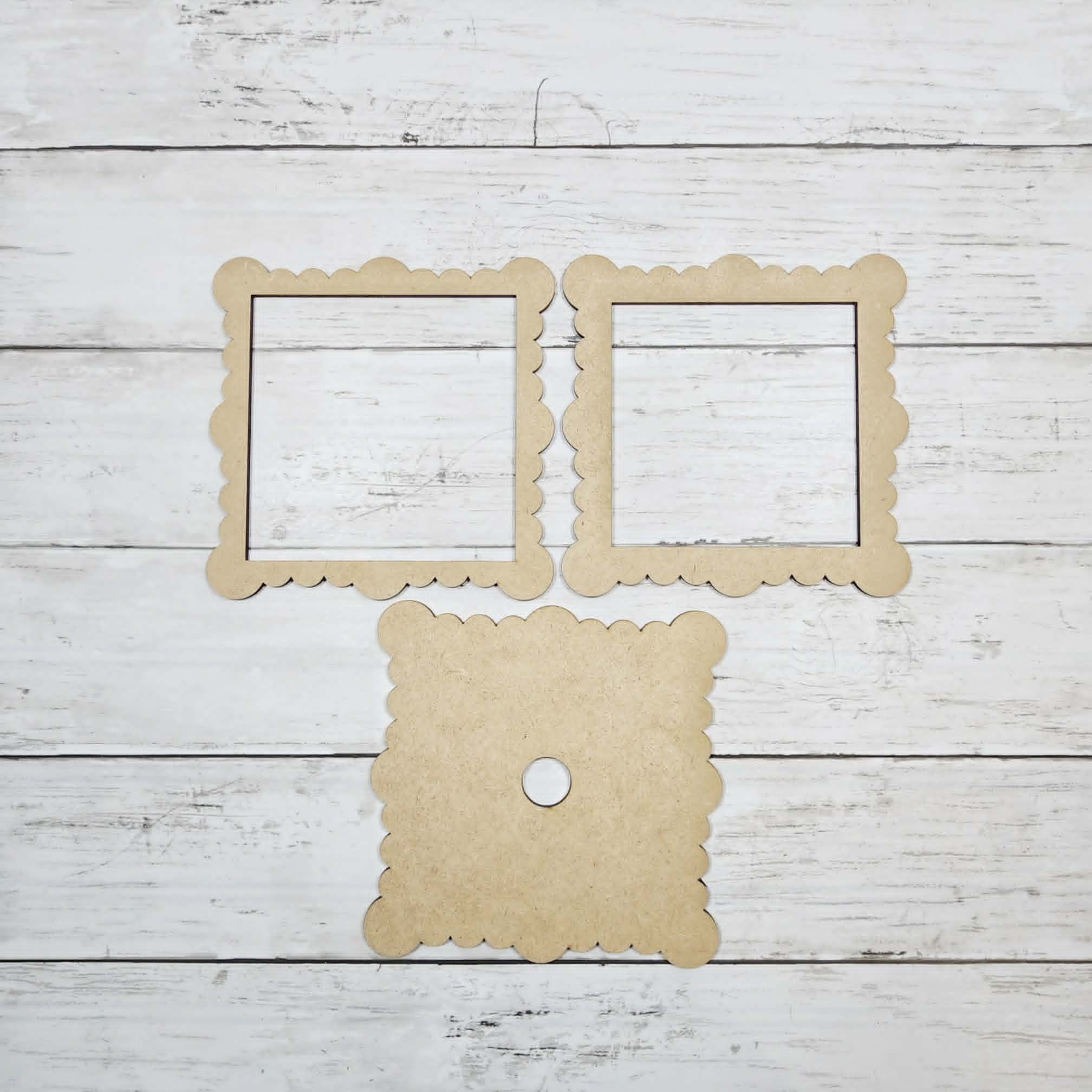 Three cardboard frames on a wooden surface