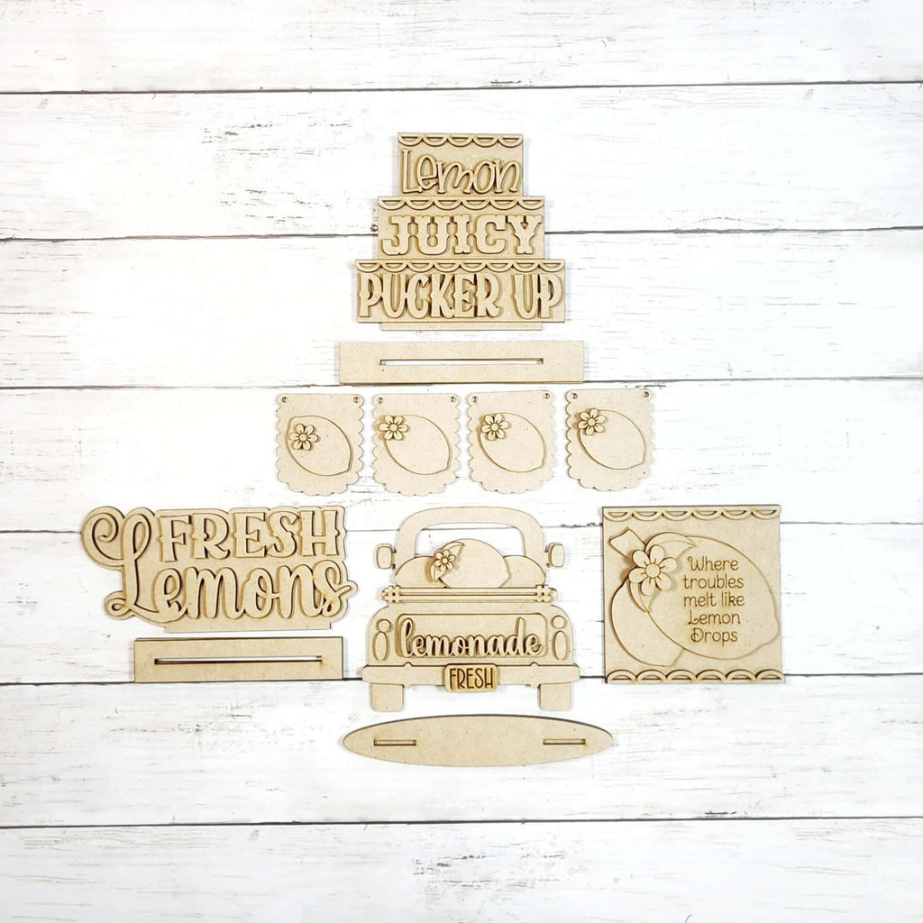 Set of wooden signs with lemon-themed phrases on a white wooden background