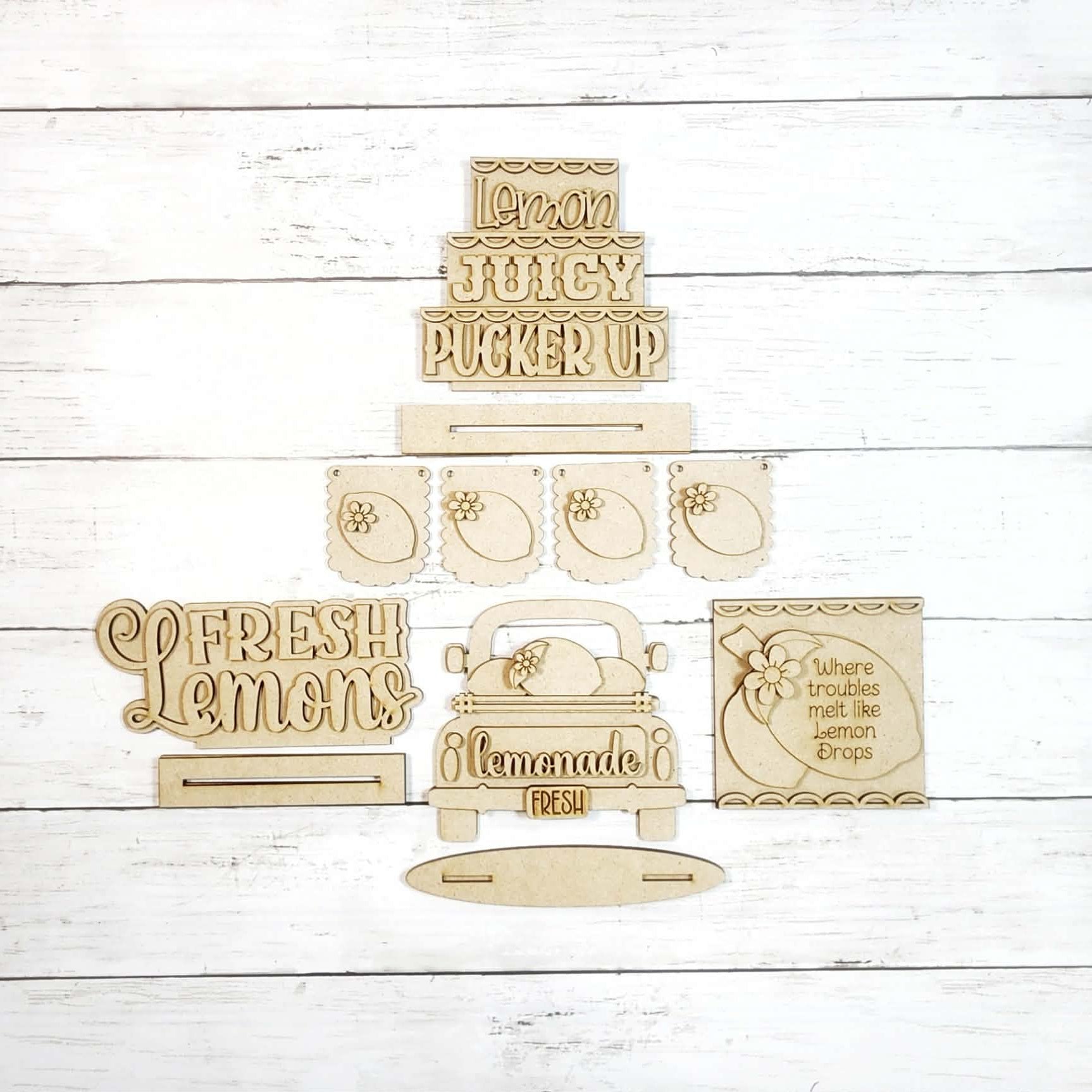 Set of wooden signs with lemon-themed phrases on a white wooden background